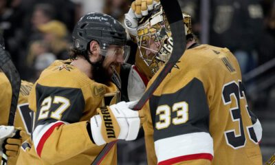 Vegas Golden Knights defenseman Shea Theodore (27) celebrates with goaltender Adin Hill (33) after Game 1 of the NHL hockey Stanley Cup Final against the Florida Panthers, Saturday, June 3, 2023