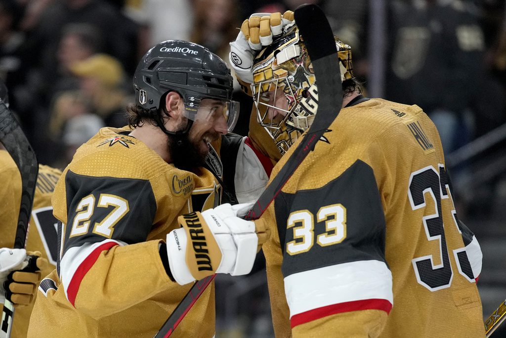 Vegas Golden Knights defenseman Shea Theodore (27) celebrates with goaltender Adin Hill (33) after Game 1 of the NHL hockey Stanley Cup Final against the Florida Panthers, Saturday, June 3, 2023