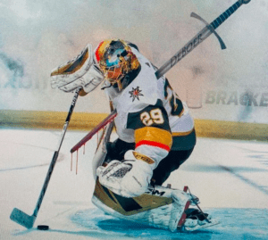 This drawing shows Former Vegas Golden Knights goaltender Marc-Andrew Fleury stopping a puck while he's speared through the heart by a long silver sword, "DeBoer" is etched on the side, indicating former head coach Pete DeBoer
