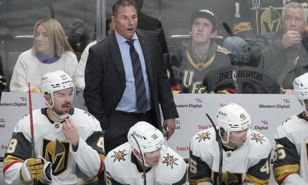 Vegas Golden Knights head coach Bruce Cassidy, standing, reacts from behind players on the bench during the third period of an NHL hockey game against the San Jose Sharks in San Jose, Calif., Tuesday, Jan. 7, 2025. (AP Photo/Jeff Chiu)