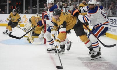 From right, Edmonton Oilers left wing Evander Kane (91), Vegas Golden Knights defenseman Brayden McNabb (3) and Edmonton Oilers center Leon Draisaitl (29) vie for the puck during the first period of Game 1 of a second-round NHL hockey playoff series Tuesday, May 6, 2025, in Las Vegas. (AP Photo/John Locher)