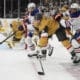From right, Edmonton Oilers left wing Evander Kane (91), Vegas Golden Knights defenseman Brayden McNabb (3) and Edmonton Oilers center Leon Draisaitl (29) vie for the puck during the first period of Game 1 of a second-round NHL hockey playoff series Tuesday, May 6, 2025, in Las Vegas. (AP Photo/John Locher)